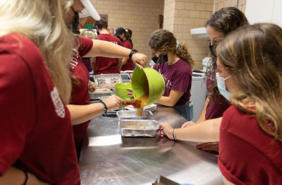 Regis volunteers prepare food on Founder's Day