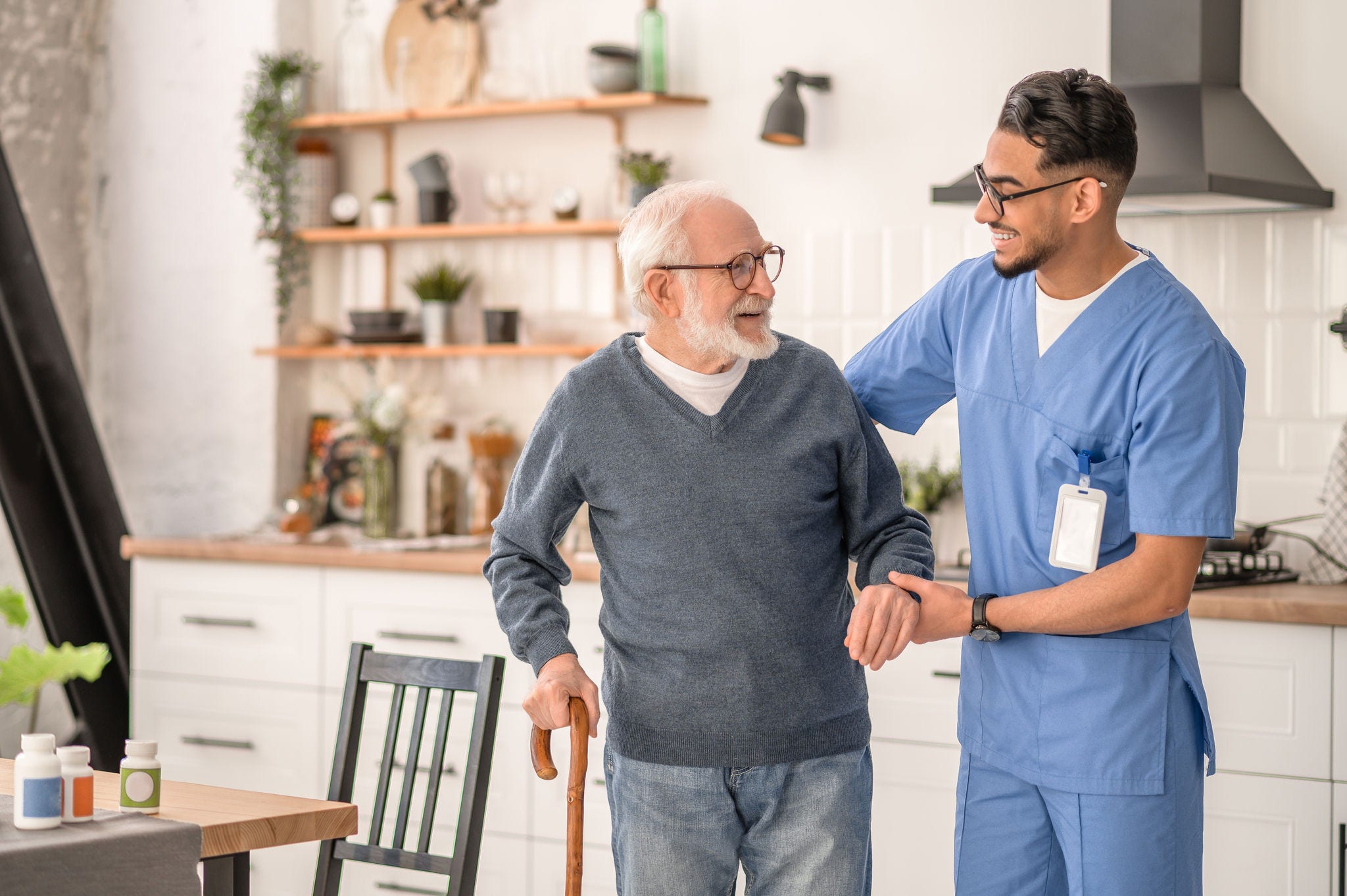 Medical worker helping his patient to move around the apartment; Shutterstock ID 2156665967; purchase_order: -; job: -; client: -; other: -