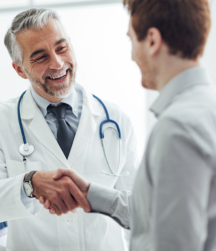 Smiling doctor at the clinic giving an handshake to his patient, healthcare and professionalism concept; Shutterstock ID 390902179; purchase_order: -; job: -; client: -; other: -