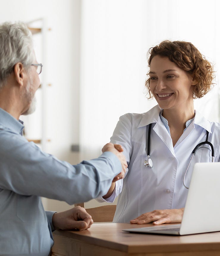 Smiling young female doctor shake hand close health insurance deal with elderly patient at consultation in hospital. Happy woman GP handshake greeting get acquainted with mature man in clinic.; Shutterstock ID 1930973966; purchase_order: -; job: -; client: -; other: -