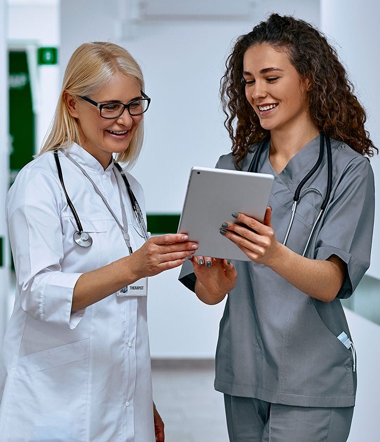 Doctors laugh and talk in the hallway. Older woman and young female doctors.; Shutterstock ID 2111434565; purchase_order: -; job: -; client: -; other: -
