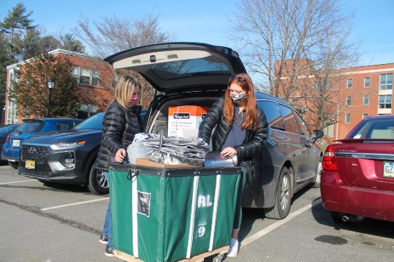Two students unload a car while moving into the Regis Weston campus