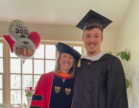 Professor Jennifer Amadon poses with her son Collin after they both earned degrees from Regis