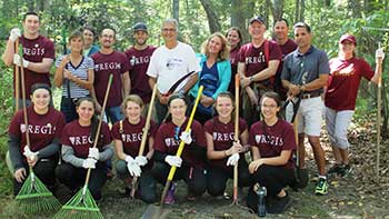 Members of the Regis community pose while working on the Weston trails.