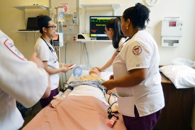 Regis nursing students working around a patient simulator