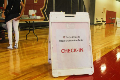 A "check-in" sign at the Regis College vaccine clinic