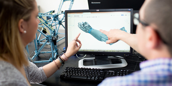 Two students reviewing a graphic of an artificial arm