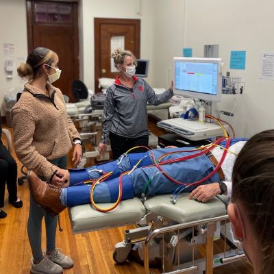 A photo of two students attending a patient in the DMS lab