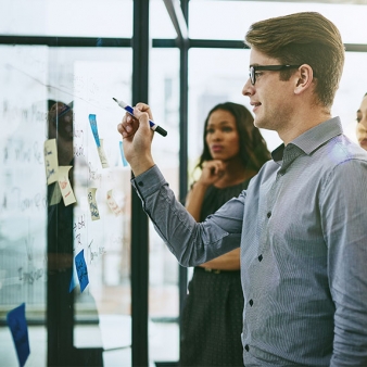 Graduate Student writing on a whiteboard