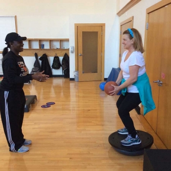 A student on a small trampoline with an exercise ball
