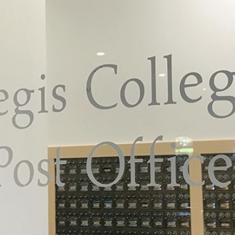 The Regis College Post Office window with student mailboxes visible inside