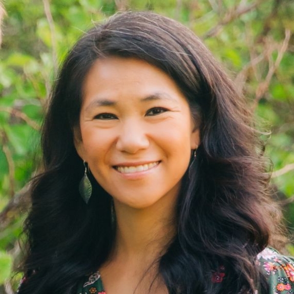 Janine Helwig smiles in front of a green background