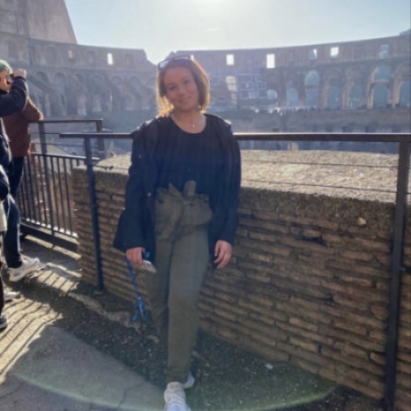 Regis student standing with Roman colosseum behind her