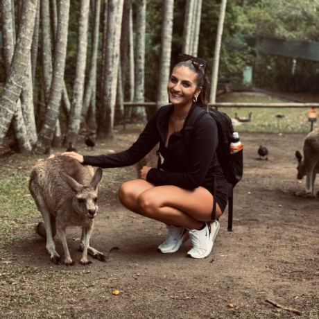 A student poses next to a kangaroo