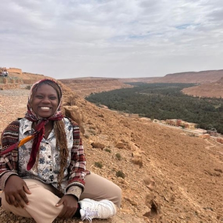 A student sits in the foreground, with landscape in the background