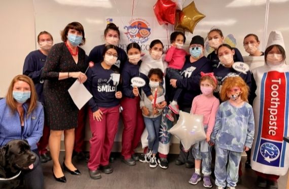 Group photo of dental hygiene students, DA Ryan, and children taking part in Give Kids A Smile 
