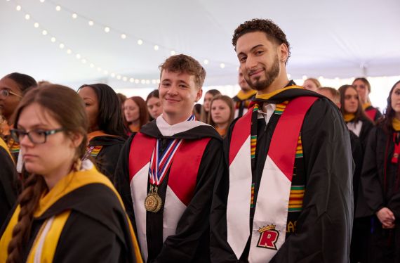 Two students in the Tower Tent in academic regalia