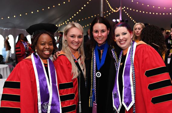 Smiling students in doctoral robes